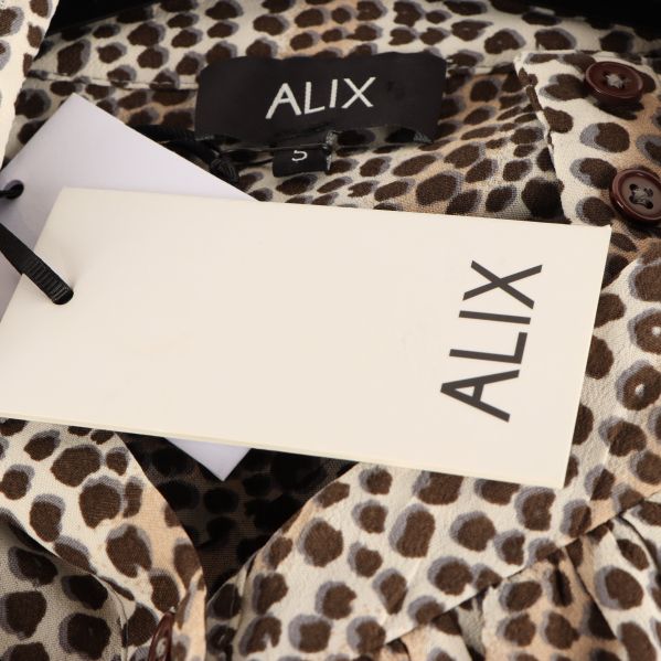 Närbild på Alix-märket på blusen