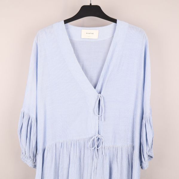 Närbild på ljusblå klänning med v-ringning