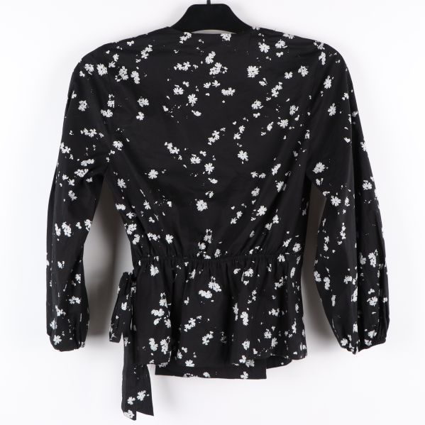 Svart blus med vitt blommönster bakifrån