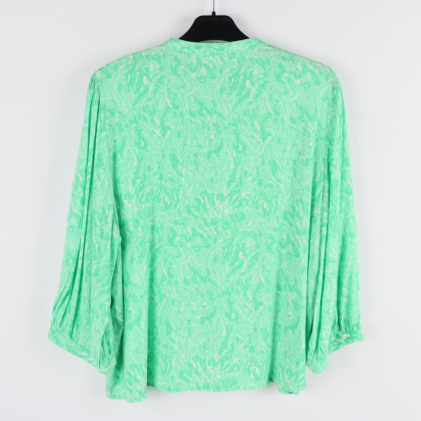 Baksidan av grön blus med abstrakt mönster