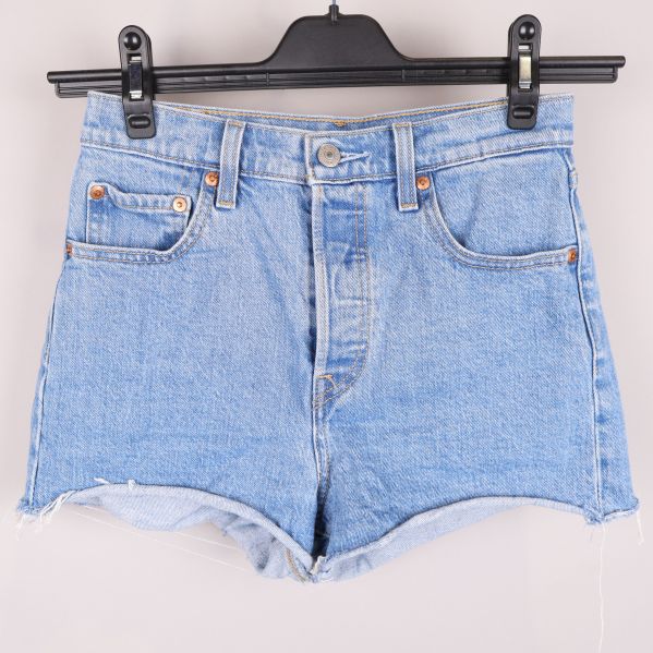 Framsidan av ljusblå jeansshorts på galge