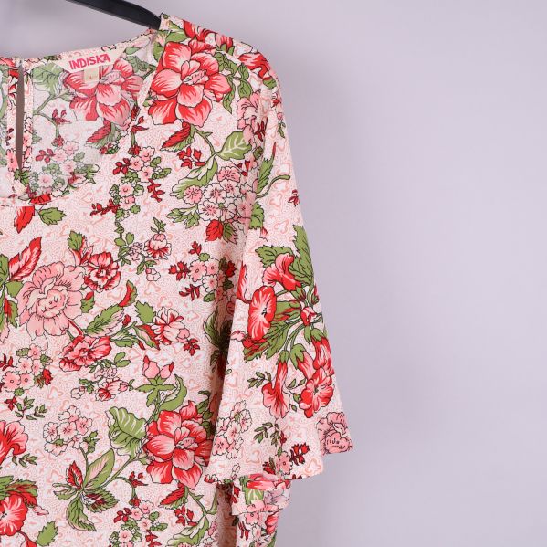 Närbild av klänningens blommiga mönster och ärmdetaljer