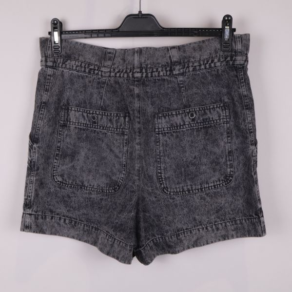 Baksidan av grå denimshorts med fickor