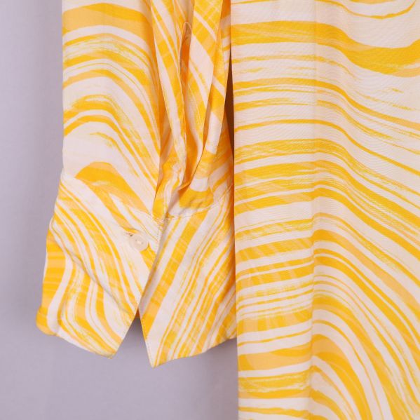 Ärmdetaljer på gul och vit klänning