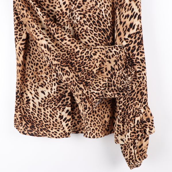 Detaljbild av ärm med volangdetaljer på leopardmönstrad blus