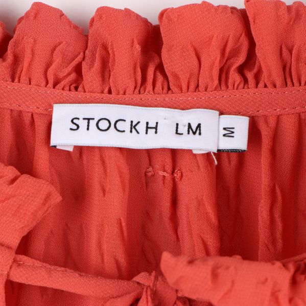 Närbild av Stockh LM etiketten på blusen