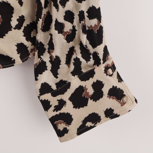 Närbild av ärm på leopardmönstrad blus