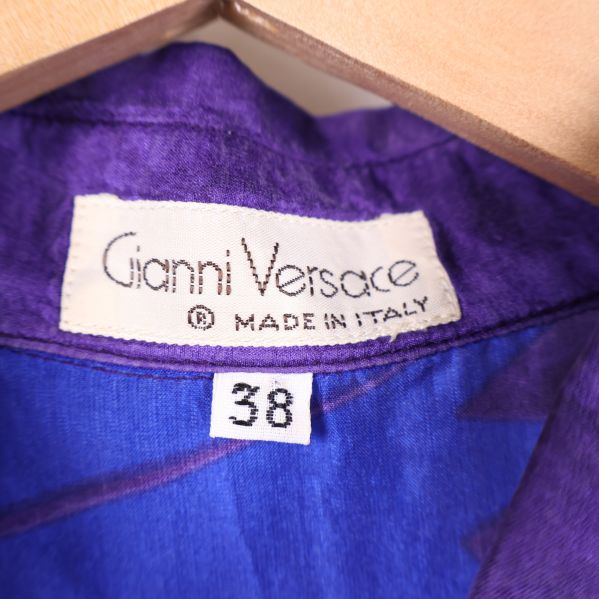 Närbild på etikett med Gianni Versace och storleken
