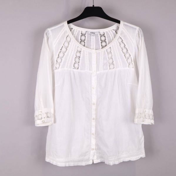 Framsidan av en vit blus med spets