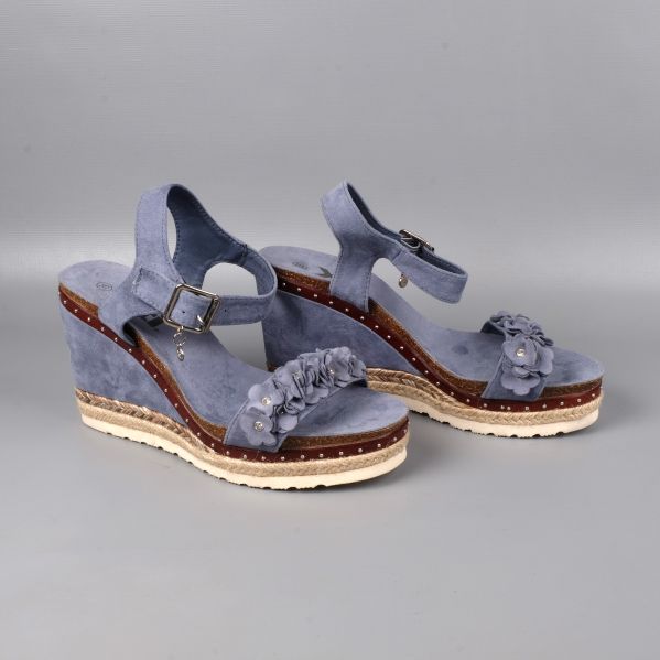 Sida av blå kilklackar med justerbara remmar