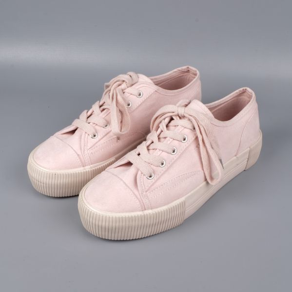 Framsida av ljusrosa sneakers med snören och platåsula