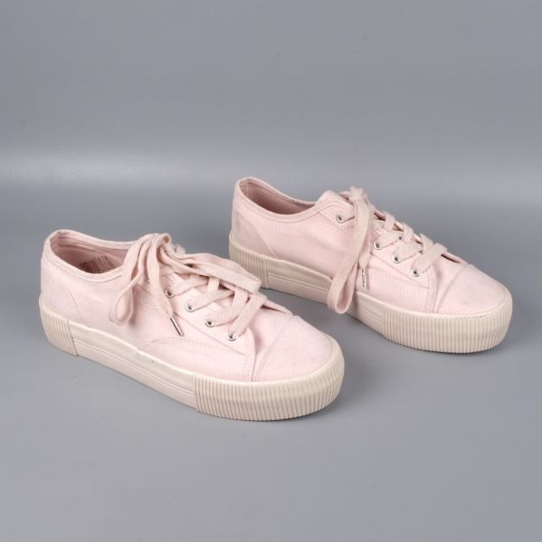 Baksida av ljusrosa sneakers med platåsula