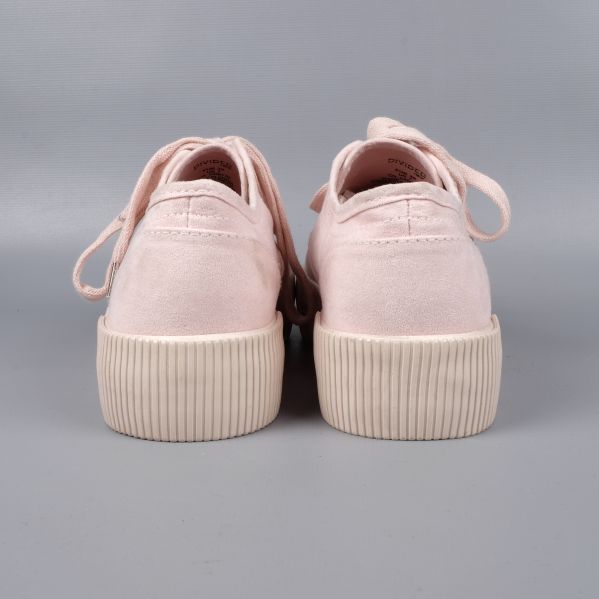 Närbild på yttersula av ljusrosa sneakers med mönster