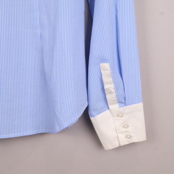 Närbild av manschett på ljusblå skjorta