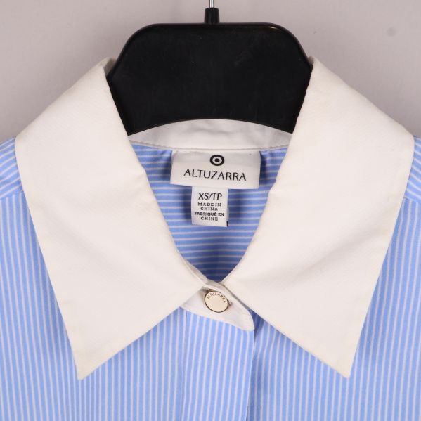 Ljusblå skjorta med vit krage på galge