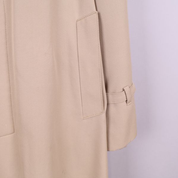 Närbild av trenchcoat ficka och ärm