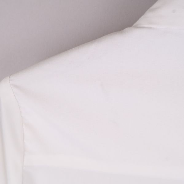 Detaljbild på axelsömnad av vit skjorta