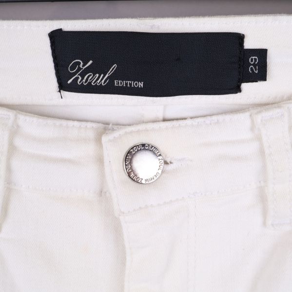 Närbild på jeansknapp och etikett 