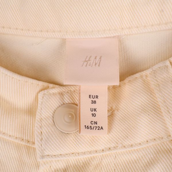 Inre etikett av krämfärgade jeans med storlek