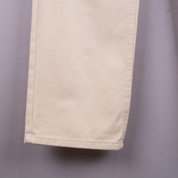 Närbild på ben nederdel av krämfärgade jeans