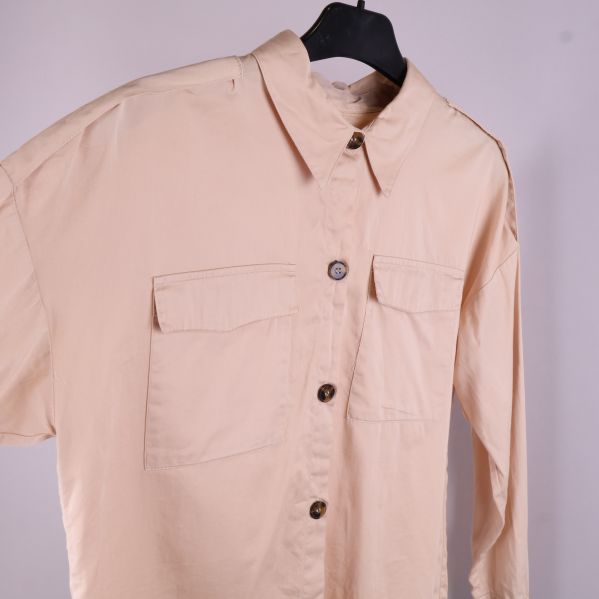 Närbild av beige skjorta med krage och knappar