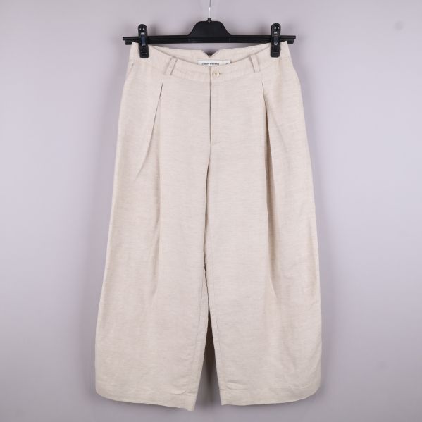 Beige byxor framifrån på galge