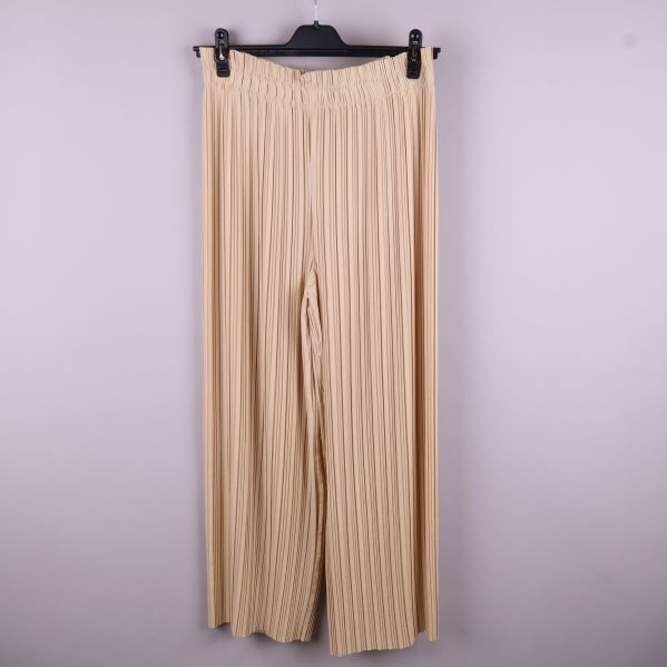 Beige plisserade byxor hängande framifrån
