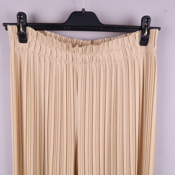 Närbild av resårmidjan på de beige byxorna