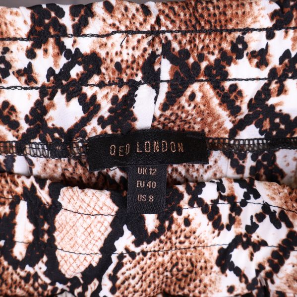 Närbild av QED London etikett