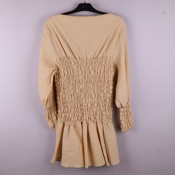 Beige klänning med smock bakifrån