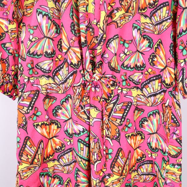 Närbild av tunika med fjärilsmönster och knytband