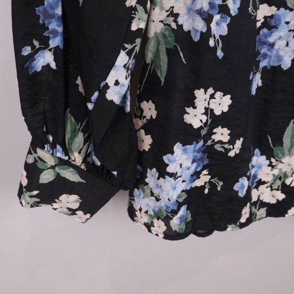 Detaljbild av blusens ärm och mönster