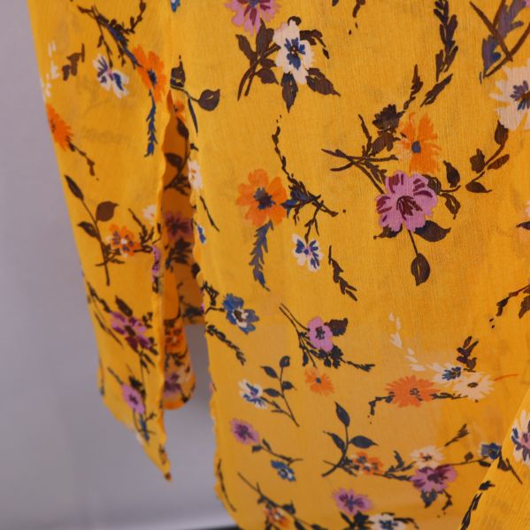Närbild på klännings tyg och blommönster