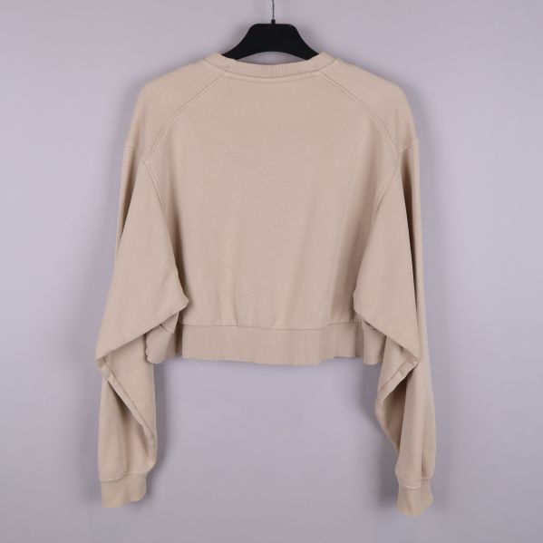 Baksida av beige cropped tröja