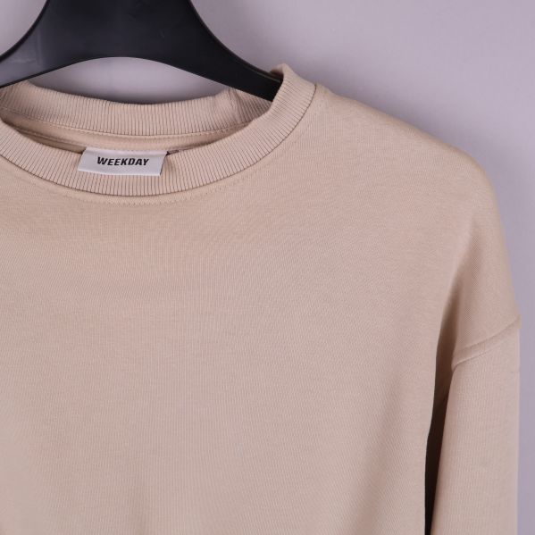 Närbild på etikett på beige tröja