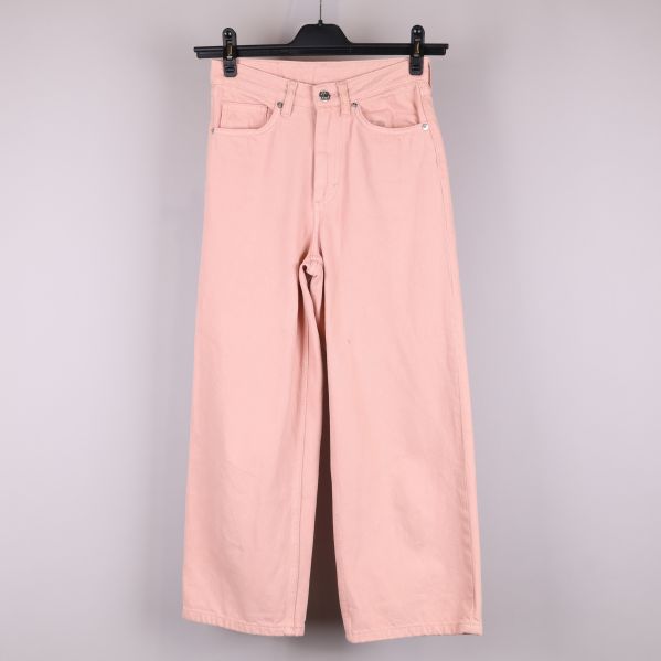 Framifrån av rosa jeans på galge