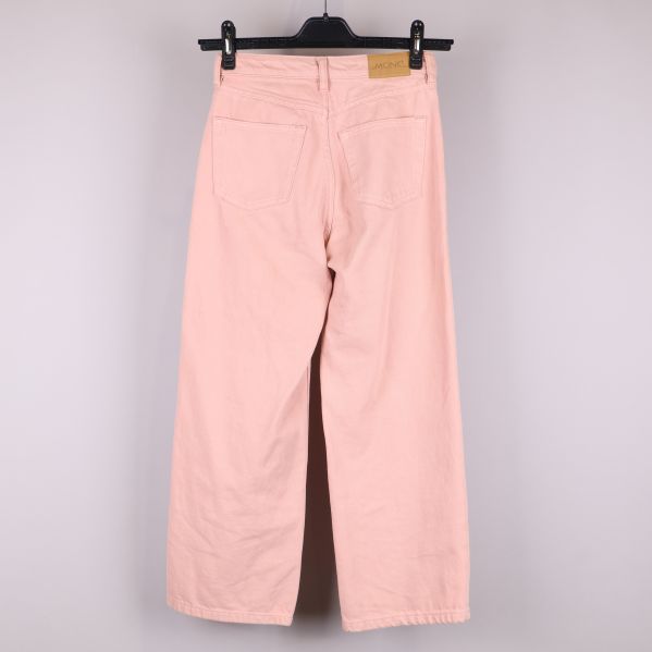 Baksida av rosa jeans på galge