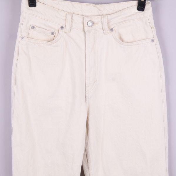 Övre del av vita jeans med knapp och fickor