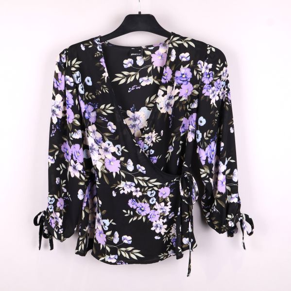 Framifrån av blommig omlottblus med lila blommor