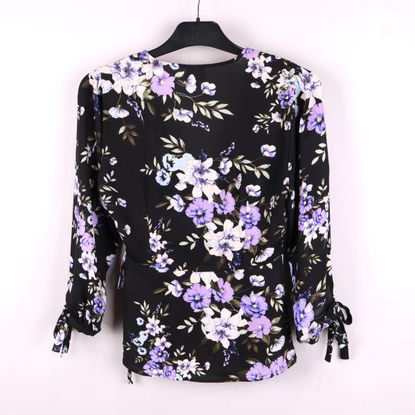 Baksidan av blommig omlottblus med lila blommor
