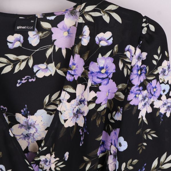 Närbild av lila blommönster på blus