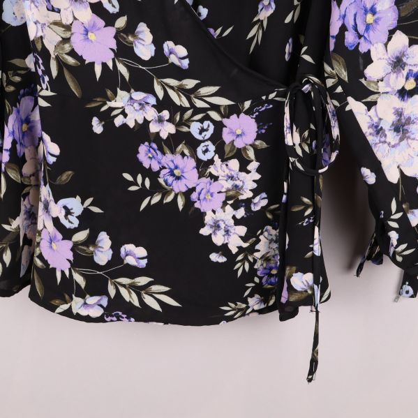 Närbild av blommig omlottblus nederdel