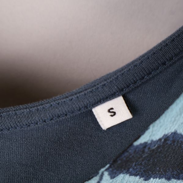 Detaljbild på klädmärke med storlek S