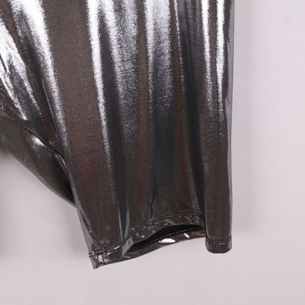 Närbild av benöppning på glittriga metallic shorts