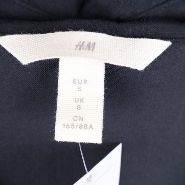 Närbild av H&M etikett på skjortklänning