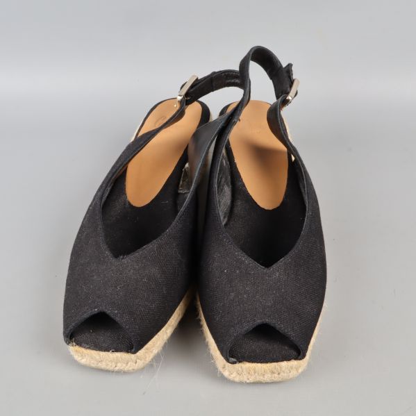 Sidovy av svarta kilklackssandaler