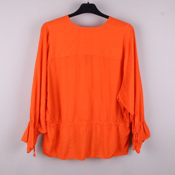 Baksida av orange blus med volanger