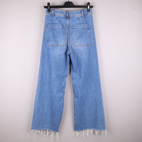 Baksidan av jeans med fickor och fransar