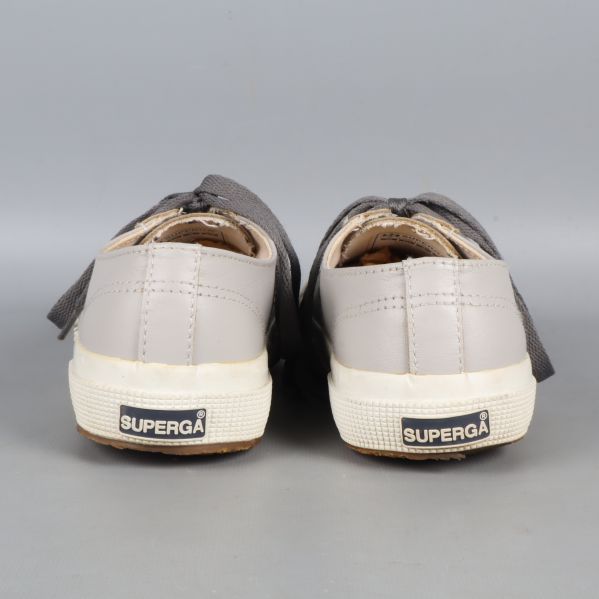 Baksida av grå sneakers med logotyp