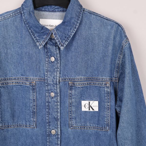 Närbild av jeansskjorta med logga